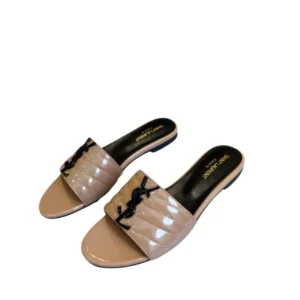 A pair of nude YSL Flat sandals with black Monogram, perfect for a stylish and versatile look.