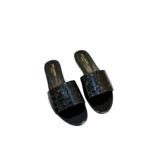 A stylish pair of YSL Monogram Black slides with a chic buckle on the side, perfect for a trendy and comfortable summer look.