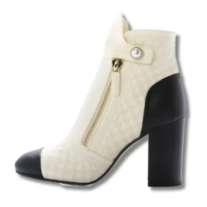 Chic Chanel Cap Toe boots in white and black leather, perfect for adding a touch of elegance to any outfit.