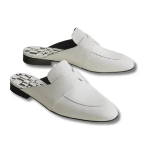White Hermes Catena mules with a sleek black heel, perfect for adding a touch of elegance to any outfit.
